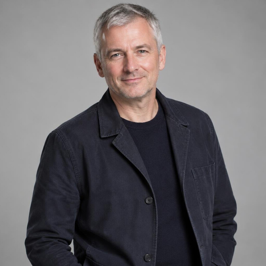 Portrait of a middle-aged man with short grey hair in a smart casual jacket